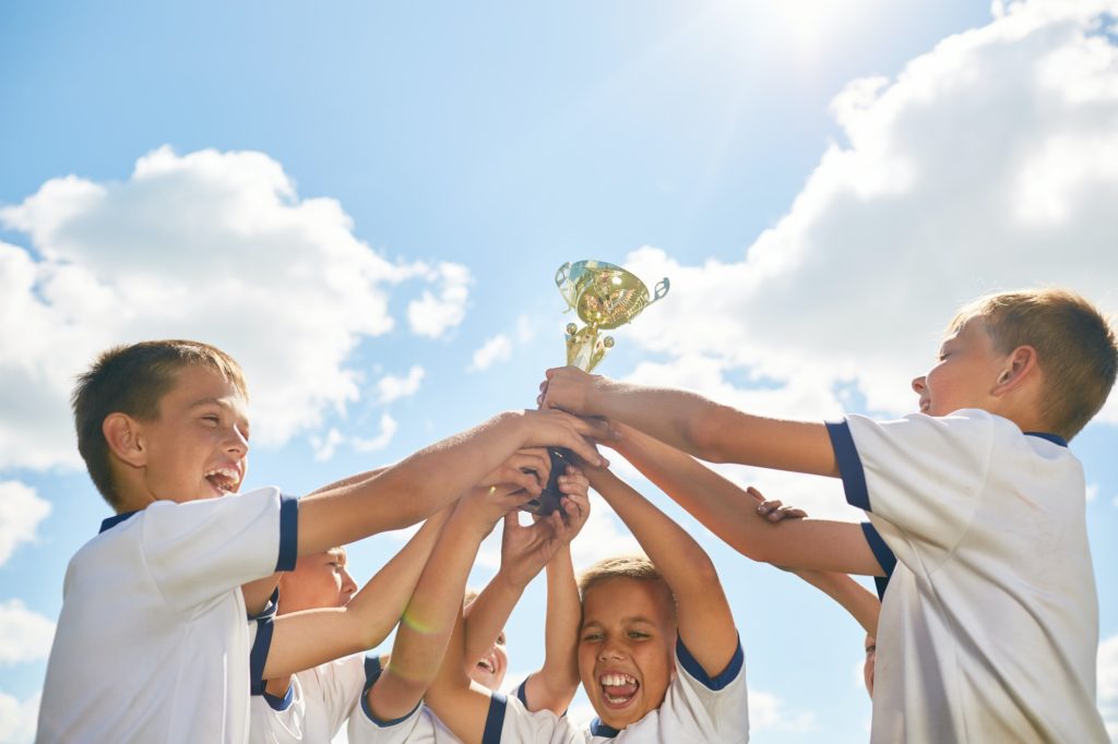 Boys Sports Team Holding Trophy